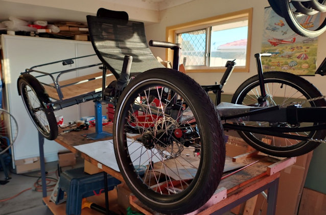 Recumbent cargo quad on a work stand to demonstrate the degree of twist available to the rear axle beam.